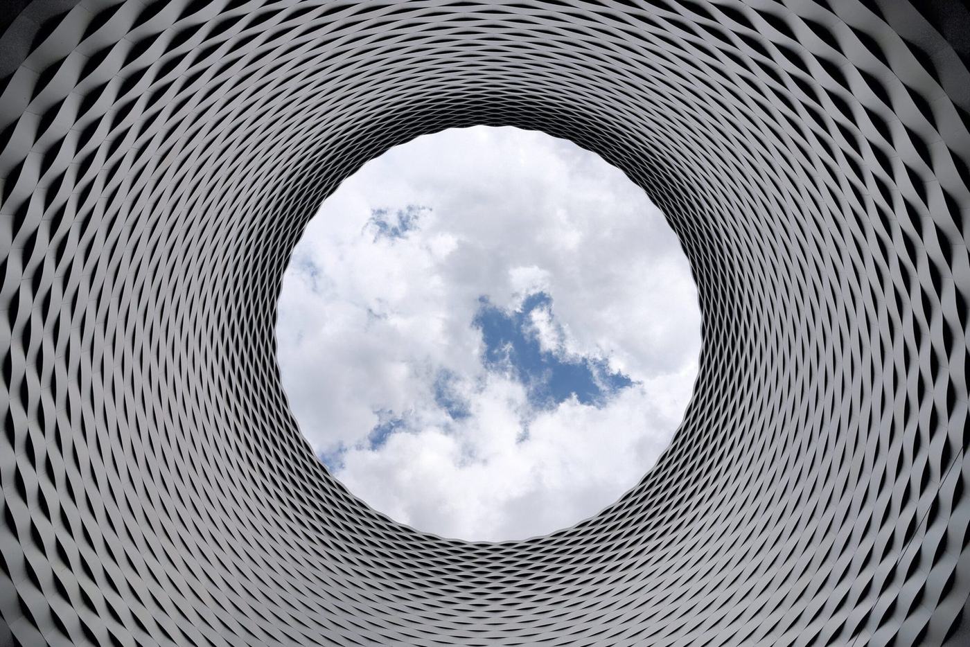 Architectural view upward through a lattice toward the sky