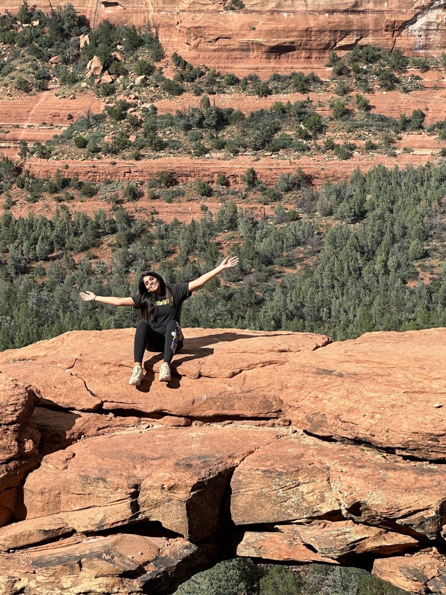 Nidhi Patel at a red-rock overlook, arms outstretched