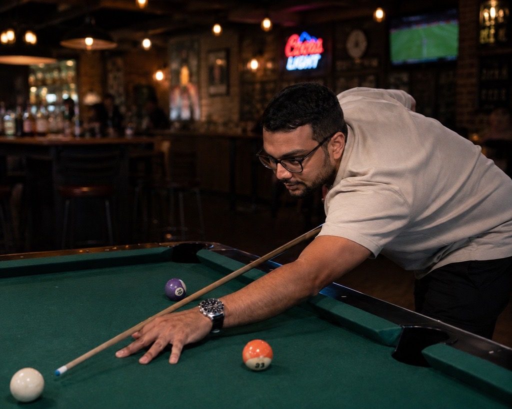 Nisarg Patel lining up a shot at the pool table