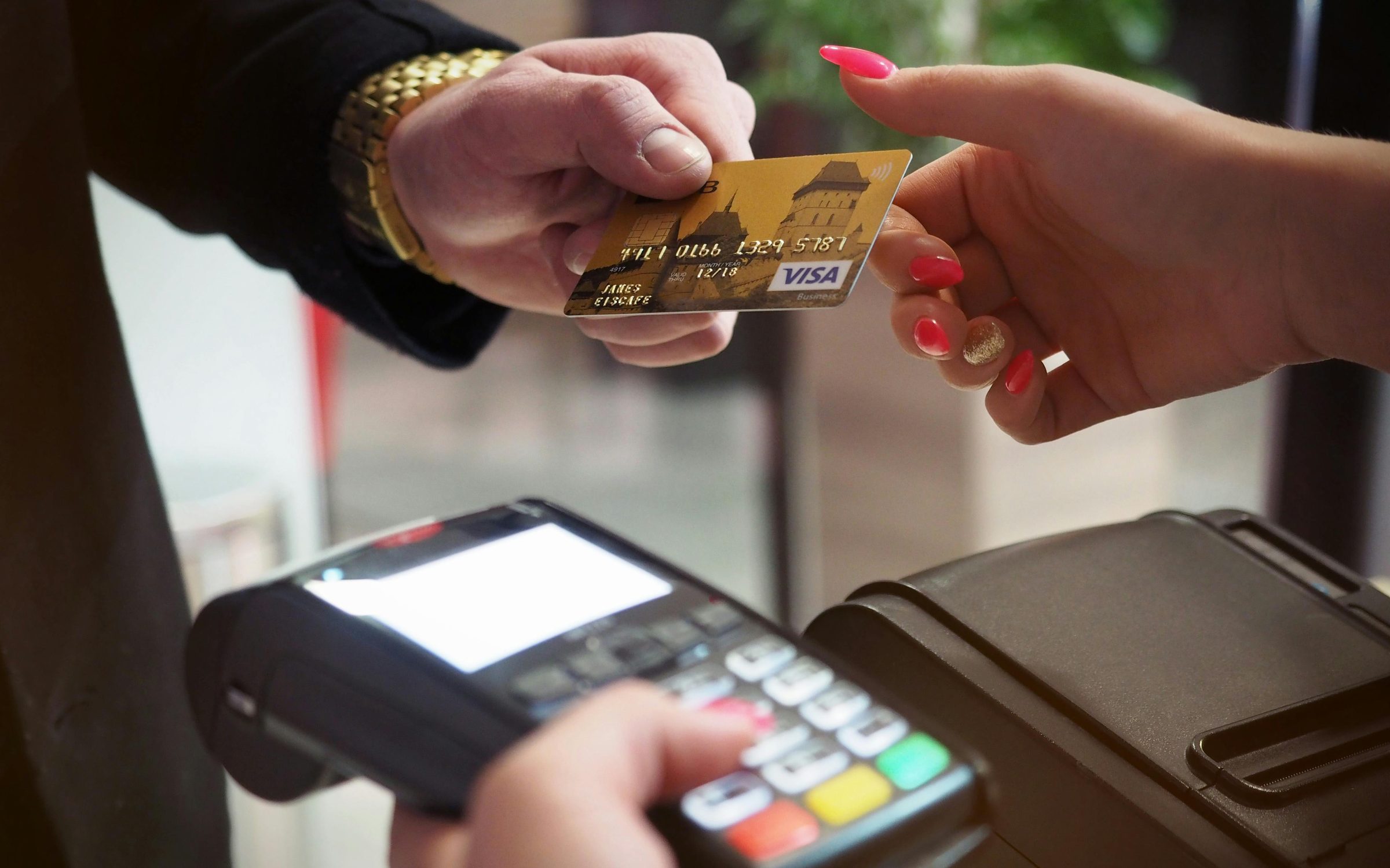Customer handing a payment card across a retail counter