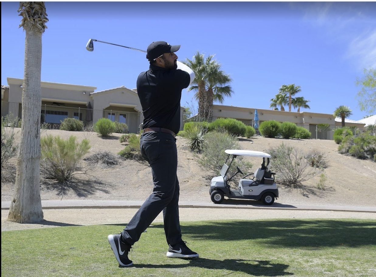 Sunny Gill mid-swing on the golf course